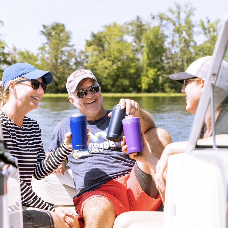 Frost Buddy Universal Buddy insulated can coolers in navy, blue and purple, in use on the water
